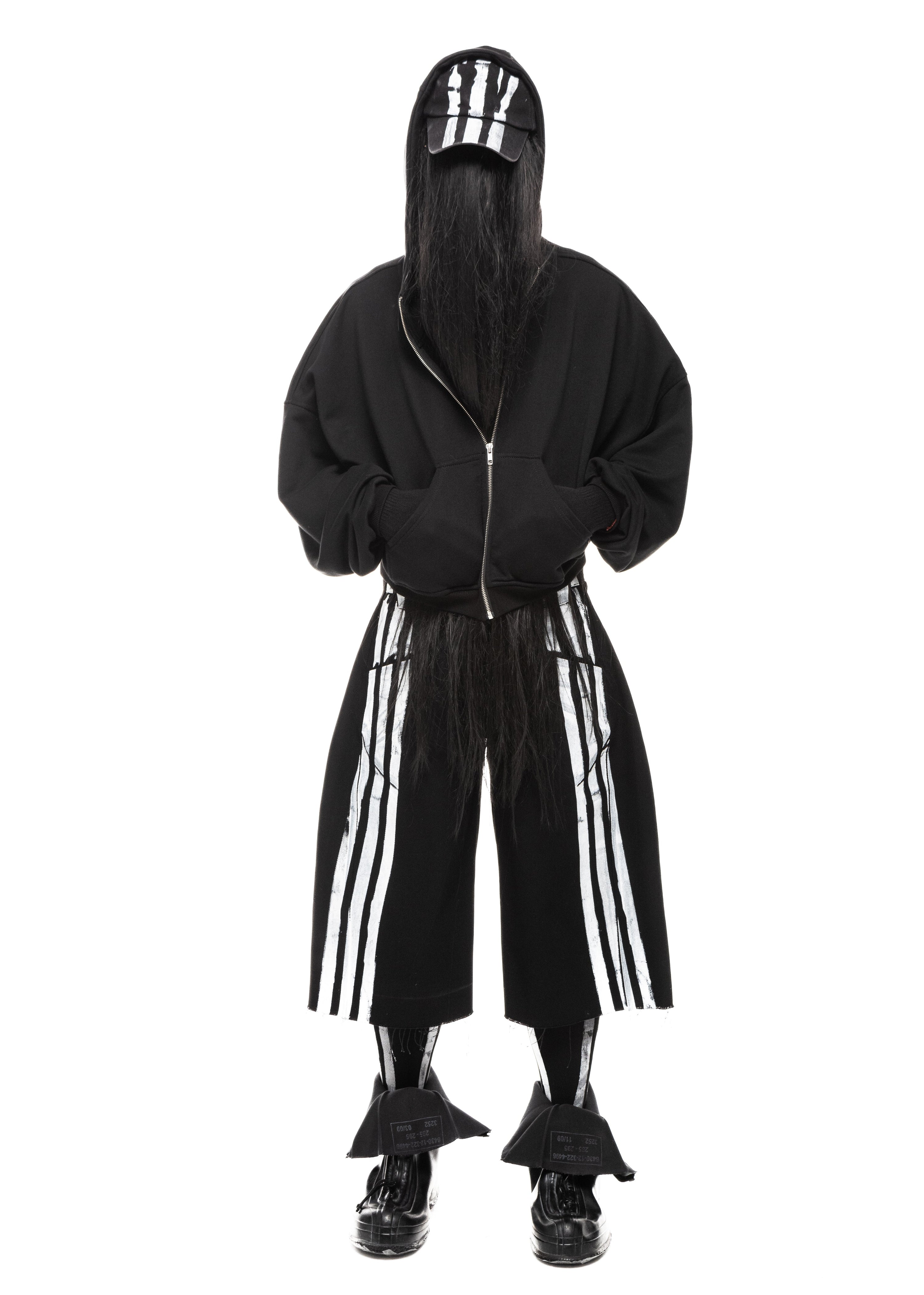 Front view of model wearing striped black denim shorts with wide-leg fit and raw hem