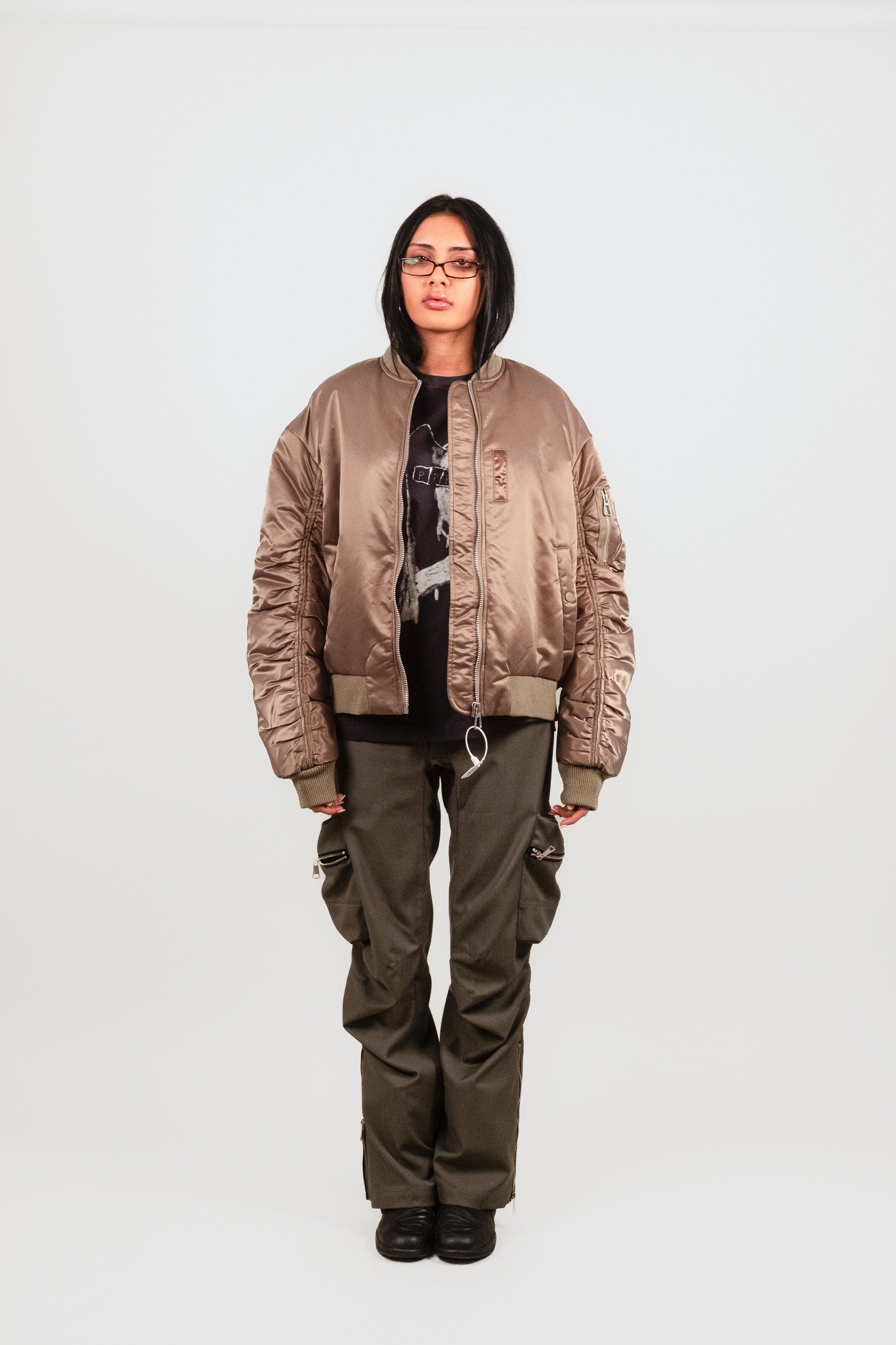 Anisa wears the Ruched Bomber — luxury reinterpretation of a vintage military bomber with ruched sleeves, oversized fit, and technical nylon shell.