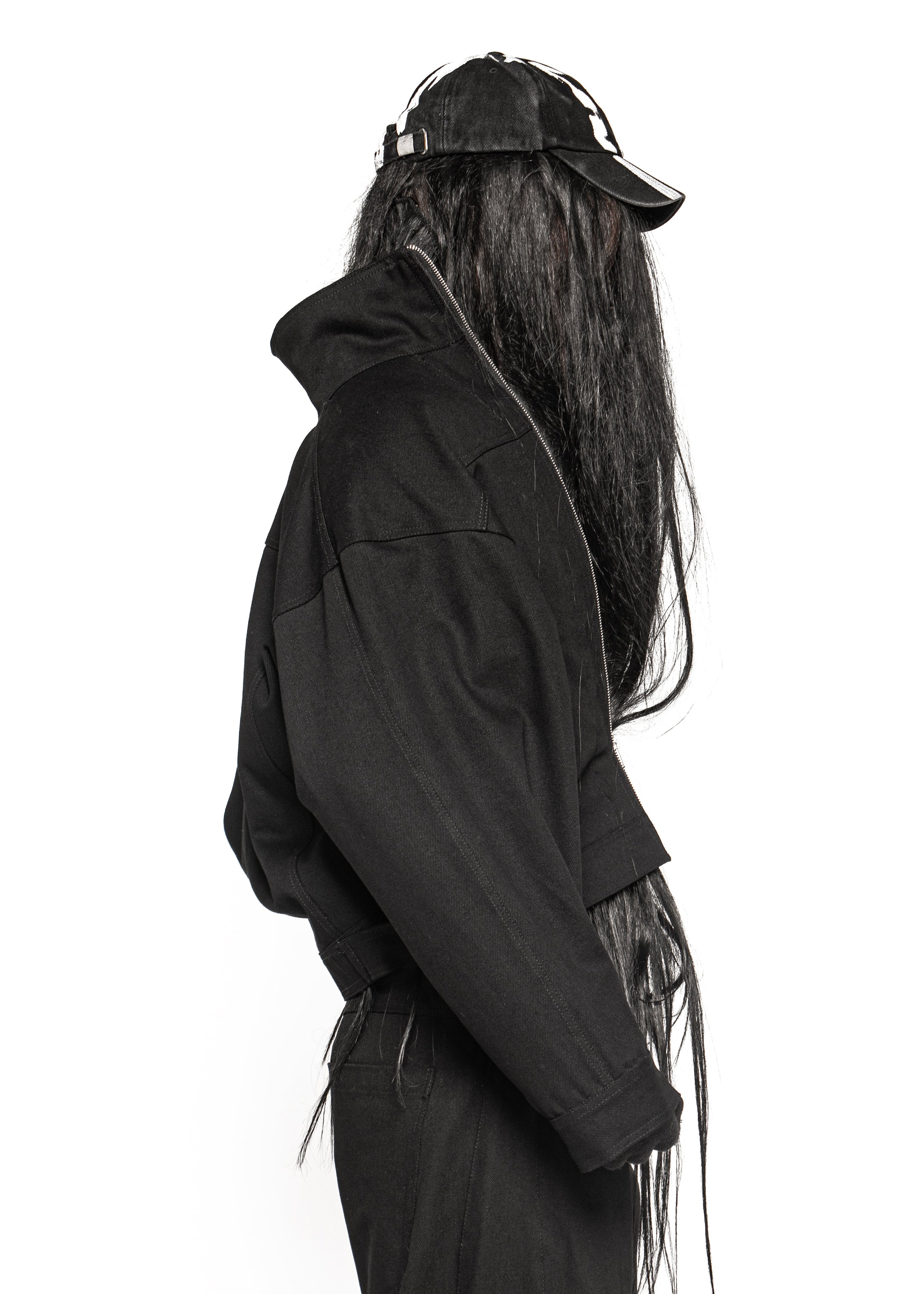 Side view of model wearing black cropped denim jacket with high collar